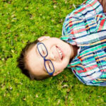 cute boy laughing on grass